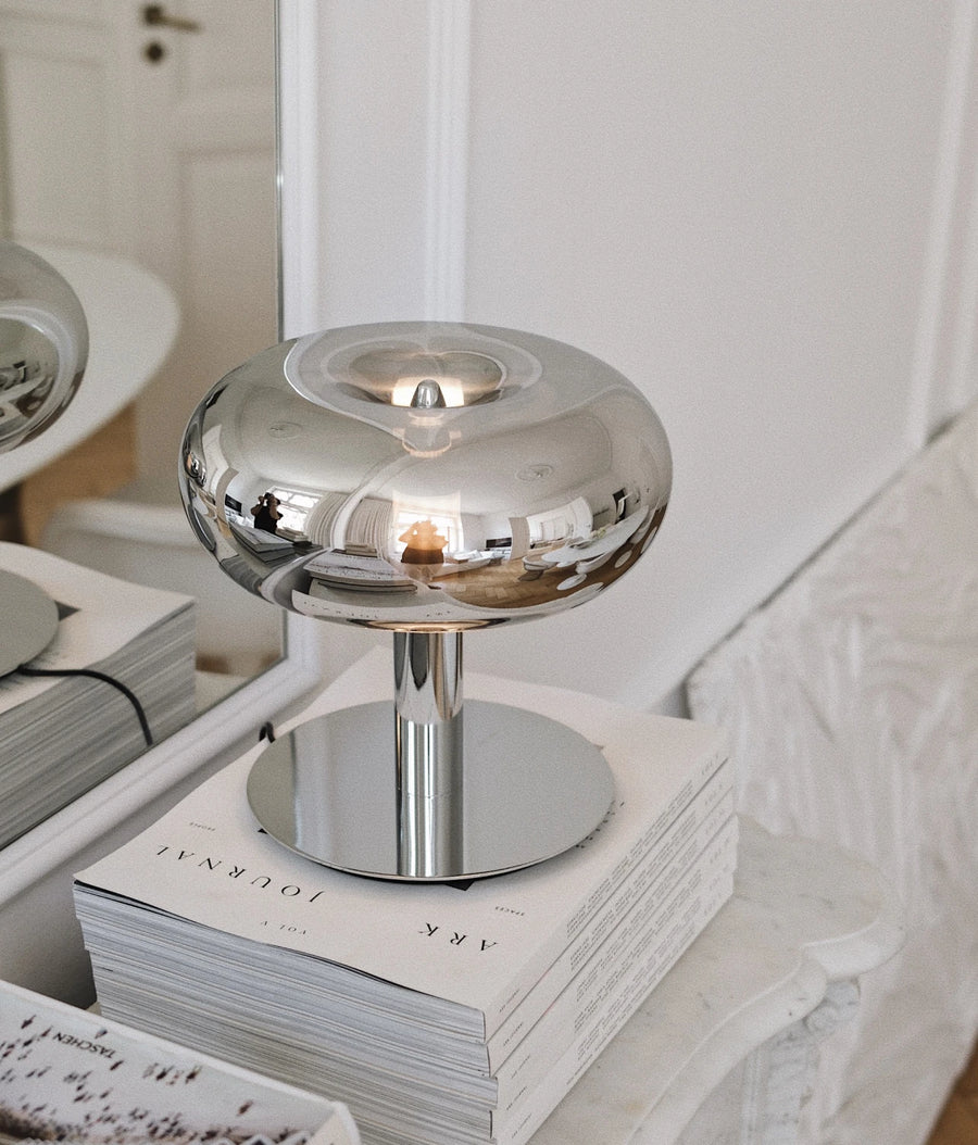 Table lamp on a console or side table, very warm light, decorative details blurred in the background (square)